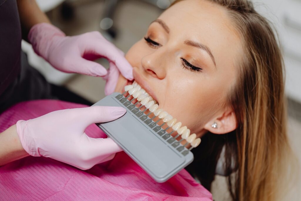 Dentist matching tooth shade for a patient during a teeth whitening consultation at Wisconsin Family Dental